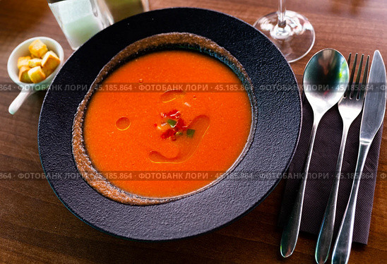 Black plate of pureed vegetable soup Gazpacho with toasted bread. Стоковое фото, фотограф Яков Филимонов / Фотобанк Лори
