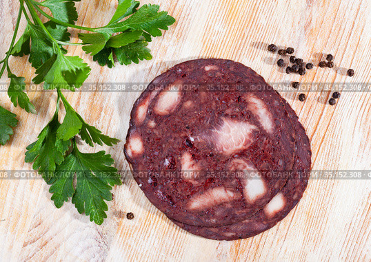 black puddingon served with parley on plate on wooden table. Стоковое фото, фотограф Яков Филимонов / Фотобанк Лори