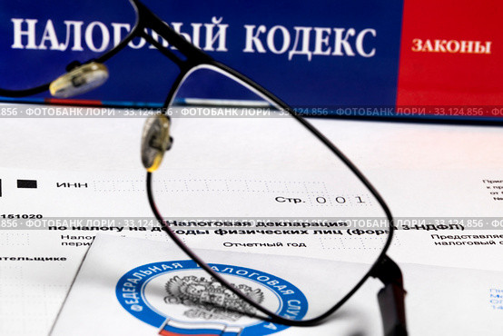 Бланк налоговой декларации на доходы физических лиц (форма 3НДФЛ) на фоне налогового кодекса Российской Федерации. Стоковое фото, фотограф Николай Винокуров / Фотобанк Лори