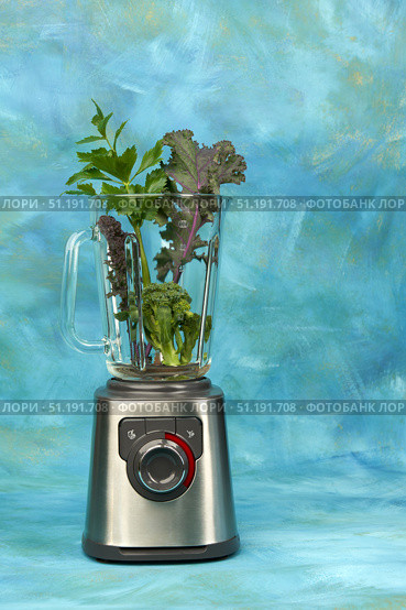 Blender with a glass flask on a beautiful blue background. In the flask are kale leaves, celery, broccoli. Стоковое фото, фотограф Роман Дзюбало / Фотобанк Лори