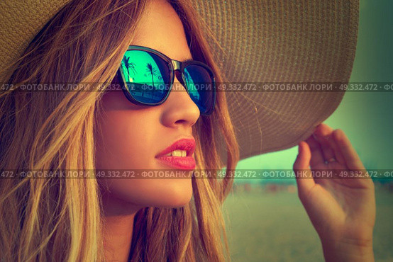 Blond teen girl sunglasses and pamela sun hat at palm tree sunset filtered image. Стоковое фото, агентство Ingram Publishing / Фотобанк Лори