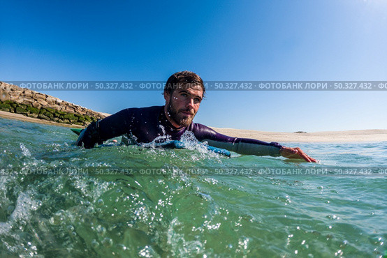 Bodyboarder rowing over the water in Furadouro beach, Ovar - Portugal. Стоковое фото, агентство Ingram Publishing / Фотобанк Лори