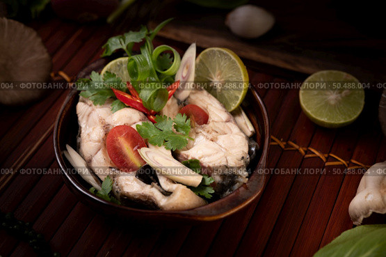 Boil the fish infusion with tomatoes, mushrooms, coriander, spring onion and lemongrass in a bowl. Стоковое фото, агентство Ingram Publishing / Фотобанк Лори