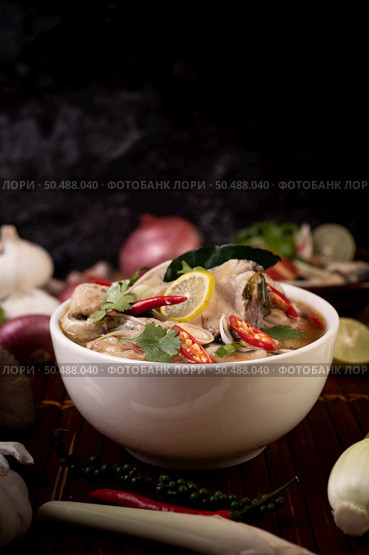 Boil the fish infusion with tomatoes, mushrooms, coriander, spring onion and lemongrass in a bowl. Стоковое фото, агентство Ingram Publishing / Фотобанк Лори