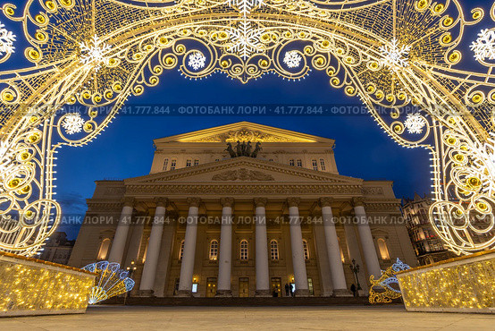 Большой театр, Москва, Россия. Вид на Театральную площадь и здание Большого театра. Вечерний городской пейзаж. Красивое новогоднее украшение города. Арка из светящихся гирлянд. Праздничное настроение. Туристическая достопримечательность. Редакционное фото, фотограф Андрей Степанов / Фотобанк Лори