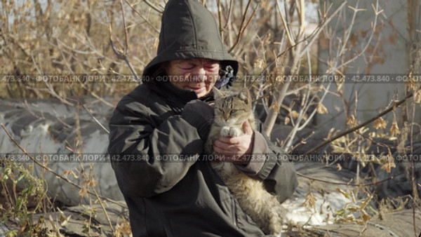 Бомж, бездомная женщина бродяга. Portrait of a homeless middle aged woman vagabond caressing a wandering cat. Стоковое видео, видеограф EStarodubov / Фотобанк Лори