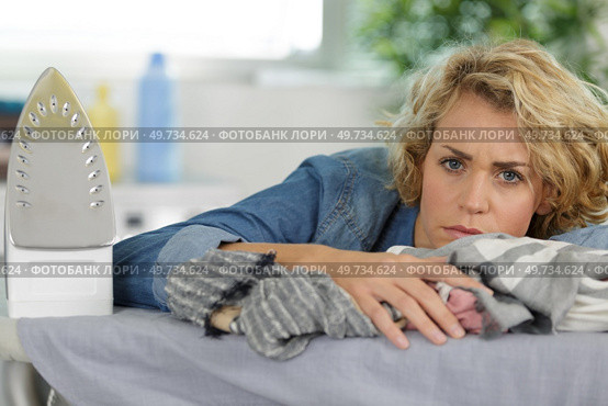 bored woman holding iron about to do ironing. Стоковое фото, агентство Ingram Publishing / Фотобанк Лори