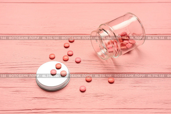 Bottle with hormonal pills on pink wooden background. Стоковое фото, фотограф Pixel_shot / Фотобанк Лори
