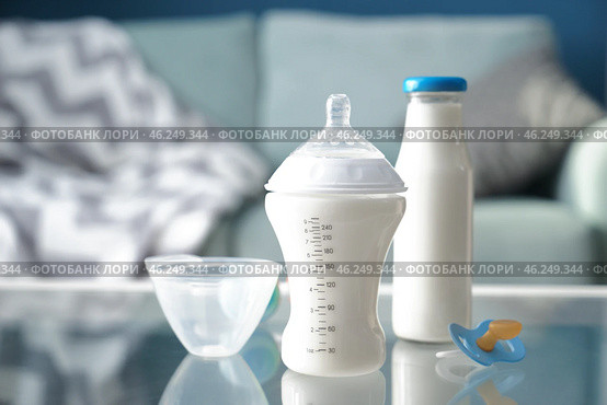 Bottles of baby formula with pacifier on glass table. Стоковое фото, фотограф Pixel_shot / Фотобанк Лори