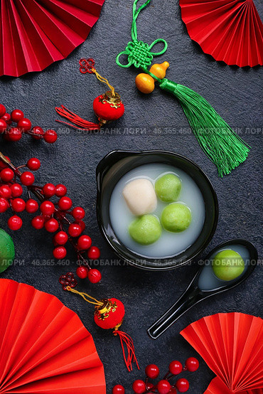 Bowl of tangyuan and Chinese decor on dark background. Dongzhi Festival. Стоковое фото, фотограф Pixel_shot / Фотобанк Лори