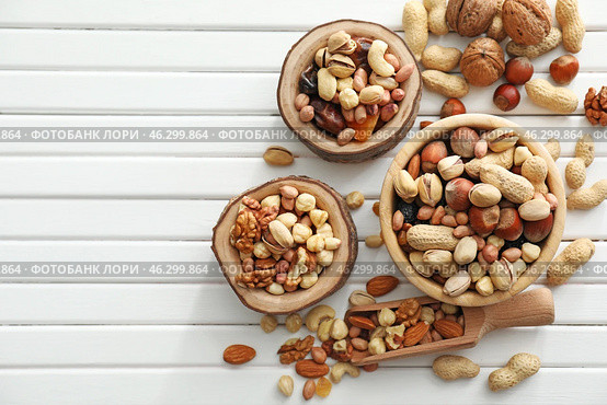 Bowls and scoop with various tasty nuts on wooden table. Стоковое фото, фотограф Pixel_shot / Фотобанк Лори