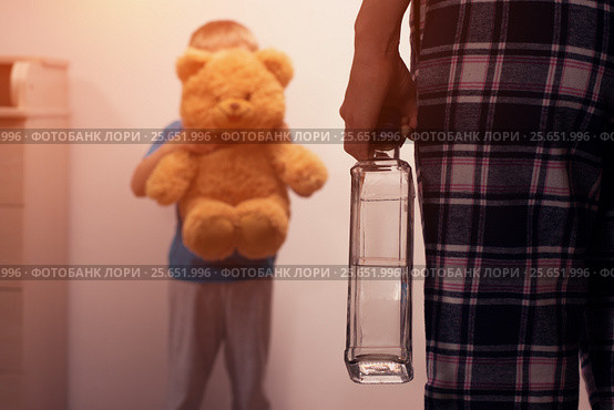 Boy covering his face with toy from drunk mother. Стоковое фото, фотограф Pavel Biryukov / Фотобанк Лори
