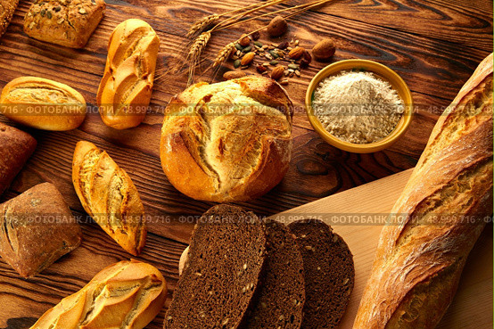 Bread fresh varied mix on golden rustic wood golden table. Стоковое фото, агентство Ingram Publishing / Фотобанк Лори