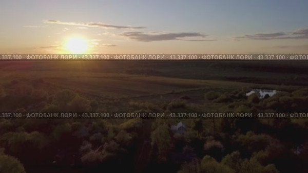 Breathtaking sunset view over green fields and forests, creating a serene atmosphere. Стоковое видео, видеограф Victor Kaprov / Фотобанк Лори