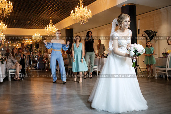 bride in a white dress throws a wedding bouquet to her unmarried girlfriends. Стоковое фото, агентство Ingram Publishing / Фотобанк Лори