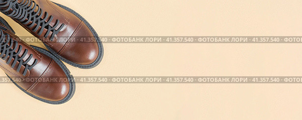 Brown shoes. Trendy Boots Pair on Neutral Beige Background. Copy space, top view, flat lay. Shoe sale, fashion concept. Stylish Casual shoes for city. Overhead shot of chelsea boots. Urban lifestyle. Стоковое фото, фотограф Марина Демидюк / Фотобанк Лори