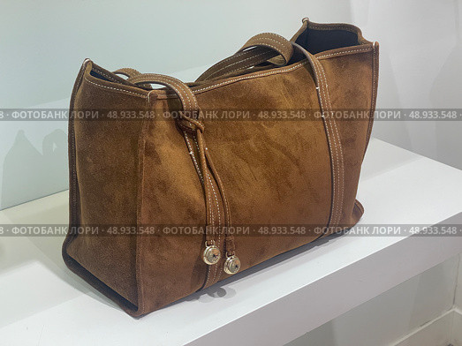 Brown suede handbag on store display. Редакционное фото, фотограф Данил Руденко / Фотобанк Лори