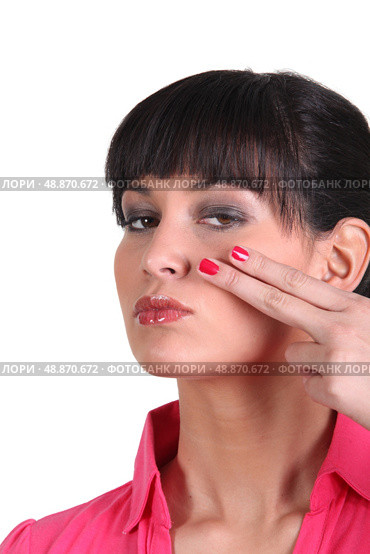 Brunette holding two finger to face. Стоковое фото, агентство Ingram Publishing / Фотобанк Лори