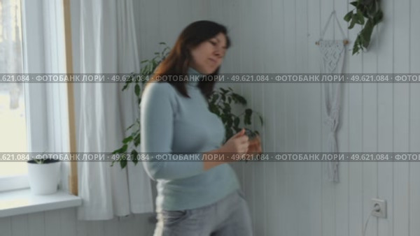 Brunette woman dance, have fun at home listens song, moves to music, feels overjoyed, celebrate good news, relish carefree life looks happy. Young adult female twirls, grooves. Lady dancing in kitchen. Стоковое видео, видеограф Марина Демидюк / Фотобанк Лори