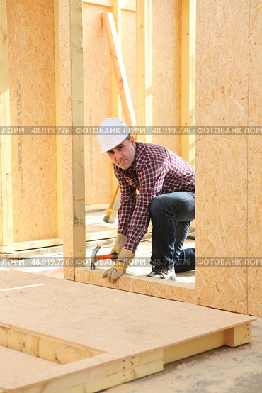 Builder constructing a house. Стоковое фото, агентство Ingram Publishing / Фотобанк Лори