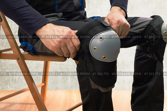 Builder man wearing protective knee pads on the legs. work safety protection equipment. Стоковое фото, фотограф Сергей Чуйко / Фотобанк Лори