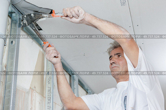 Builder mounting a metal frame. Стоковое фото, агентство Ingram Publishing / Фотобанк Лори