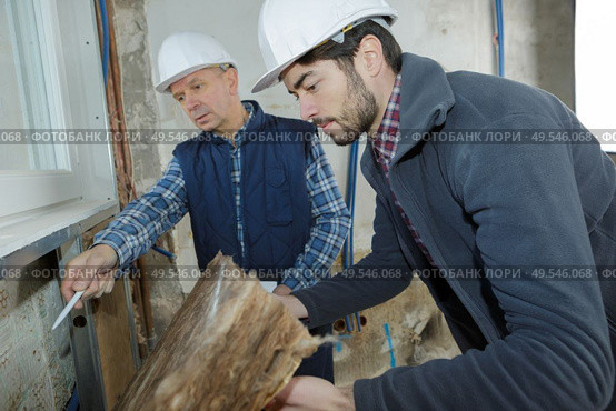 builders checking mineral wool panels stack. Стоковое фото, агентство Ingram Publishing / Фотобанк Лори