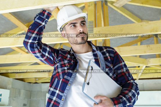 building inspector looking at roof timbers. Стоковое фото, агентство Ingram Publishing / Фотобанк Лори
