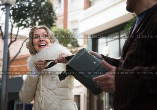 Burglar stealing bag of female pensioner. Стоковое фото, фотограф Татьяна Яцевич / Фотобанк Лори
