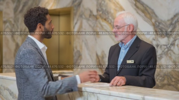 Businessman checking in at hotel reception. Стоковое AI-видео, аниматор Юрий Поздников / Фотобанк Лори