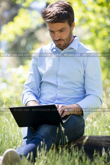 businessman sitting on the grass is working on laptop. Стоковое фото, агентство Ingram Publishing / Фотобанк Лори