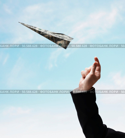 Businessman’s hand throwing airplane made of US Dollars. 24316759. Стоковое фото, агентство Ingram Publishing / Фотобанк Лори