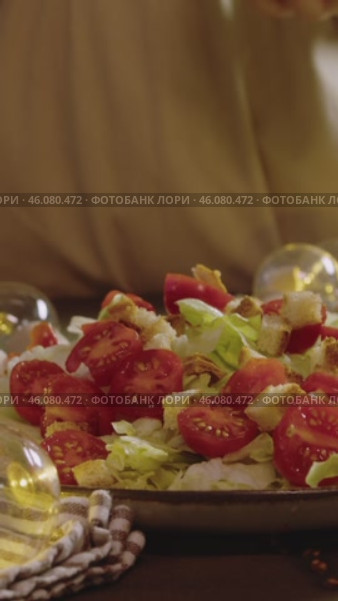Caesar salad with cherry tomatoes and iceberg lettuce, generously topped with croutons. Vertical. Стоковое видео, видеограф Strunov David / Фотобанк Лори