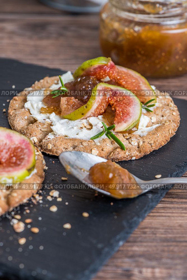 Canape or crostini with multigrain  crispread with cream cheese and fig jam on a slate board. Delicious appetizer ideal as an aperitif. Стоковое фото, агентство Ingram Publishing / Фотобанк Лори
