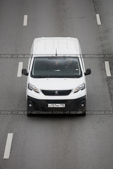 Cargo van Peugeot Expert driving in the city street. White minivan in motion, front view above. Редакционное фото, фотограф Константин Григорьев / Фотобанк Лори