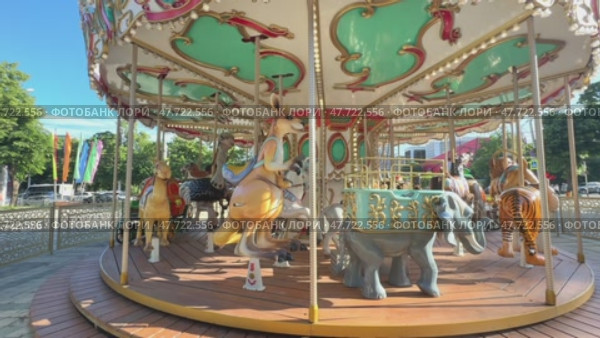 Carousel in an amusement park. Merry go round. The concept of summer holidays and school holidays. Slow notion footage. Стоковое видео, видеограф Ирина Михайличенко / Фотобанк Лори