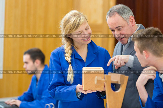 carpenter with female apprentice planing wood in workshop. Стоковое фото, агентство Ingram Publishing / Фотобанк Лори