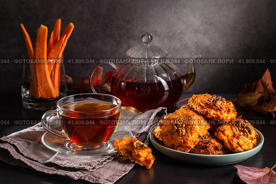 Carrot cookies with walnuts and tea in a cup against a dark background. Стоковое фото, фотограф Ирина Толокновская / Фотобанк Лори