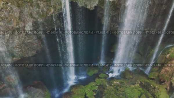 Cascading waterfall plummeting from jagged rocky cliff into verdant basin, surrounded by lush greenery in scenic turkish wilderness. Стоковое видео, видеограф ILIA GOROKHOV / Фотобанк Лори