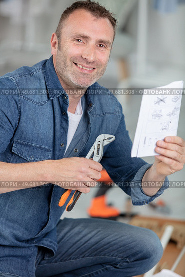 casual man reading instruction manual. Стоковое фото, агентство Ingram Publishing / Фотобанк Лори