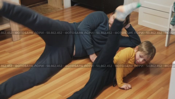 Caucasian bearded strong father with one child boy doing push ups on floor in living room. Family fitness gym at home. Sporty dad and son piggy back having fun exercise. Funny sport with kid. 4k video. Стоковое видео, видеограф Марина Демидюк / Фотобанк Лори