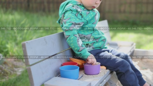 caucasian child boy kid playing sandbox sand plastic molds outside yard sunny day. Стоковое видео, видеограф Olesia Kondrateva / Фотобанк Лори