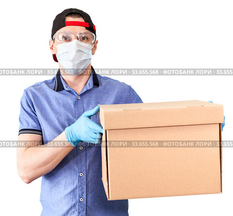 Caucasian deliveryman wearing plastic glasses, medical mask and blue neoprene gloves holding cardboard, isolated on white background. Стоковое фото, фотограф Кекяляйнен Андрей / Фотобанк Лори