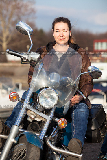 Caucasian woman with her motorcycle, front view, looking at camera. Стоковое фото, фотограф Кекяляйнен Андрей / Фотобанк Лори