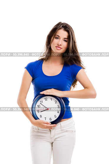 Causal young woman holding a clock, isolated over a white background. Стоковое фото, агентство Ingram Publishing / Фотобанк Лори