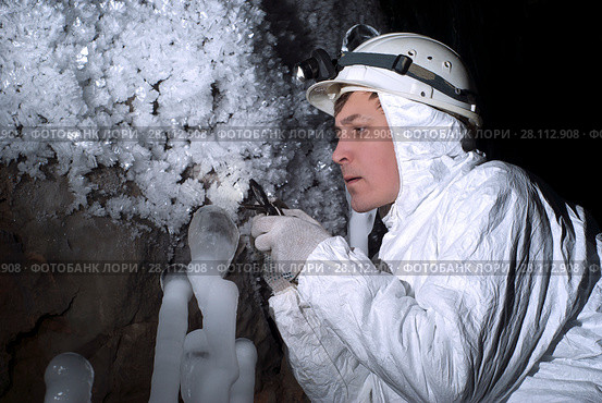 Cave explorer carefully examines the structure of the ice formations through a magnifying glass. Стоковое фото, фотограф Евгений Харитонов / Фотобанк Лори