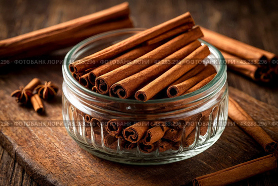 Ceylon cinnamon sticks in glass plate on wooden board, rustic style. Still life natural food of sri lankan cinnamon sticks on table at grey wall. Delicious tasty healthy concept. Copy ad text space. Стоковое AI-изображение, AI-художник Aleksandr Golubev / Фотобанк Лори