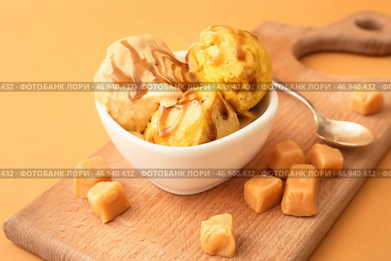 Чаша с вкусными шариками мороженого с карамелью на цветном фоне. Стоковое фото, фотограф Pixel_shot / Фотобанк Лори