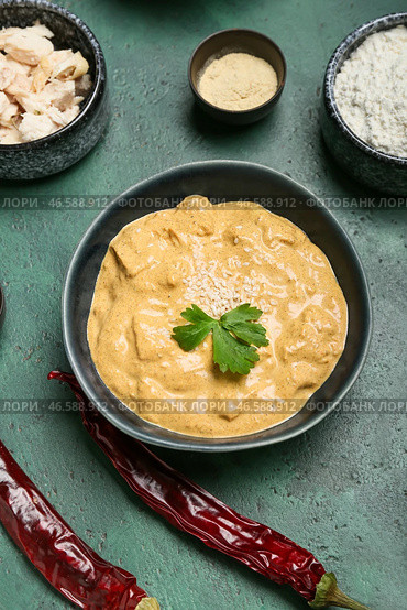 Чаша вкусного куриного карри и ингредиентов на цветном фоне. Стоковое фото, фотограф Pixel_shot / Фотобанк Лори