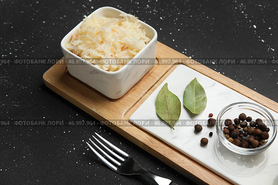 Чаша вкусной квашеной капусты с лавровыми листьями и горошком на черном фоне. Стоковое фото, фотограф Pixel_shot / Фотобанк Лори
